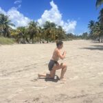 a woman doing lunges on a beach
