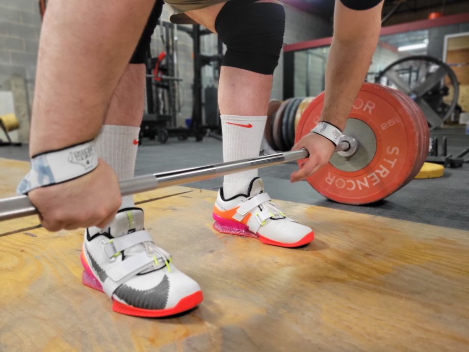 Man gripping barbell for deadlifts using Bear Grips Lifting Straps