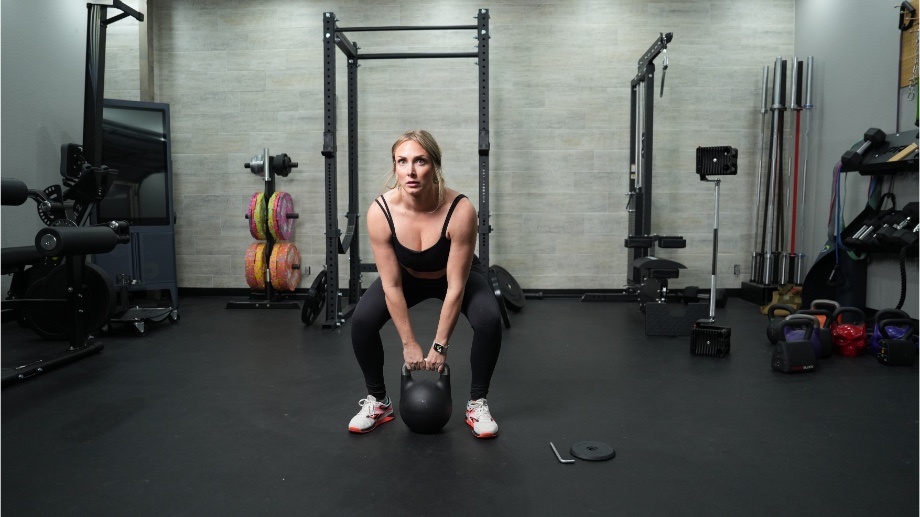 A woman setting down the Bells of Steel Adjustable Kettlebell.