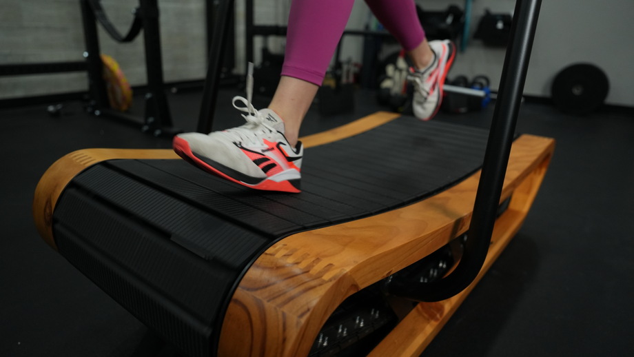 A close look at someone running on the Bells of Steel Manual Treadmill.