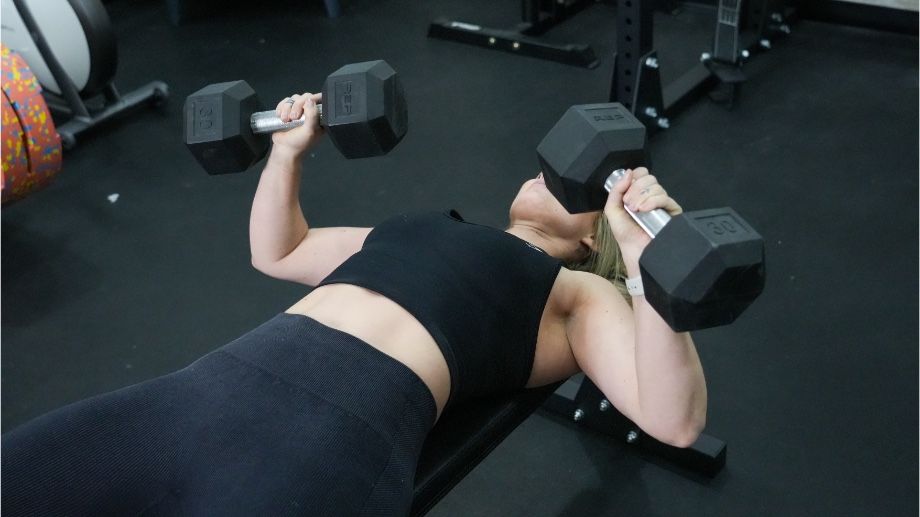 A close look at a person doing bench presses on the Bells of Steel Flat Utility Bench.