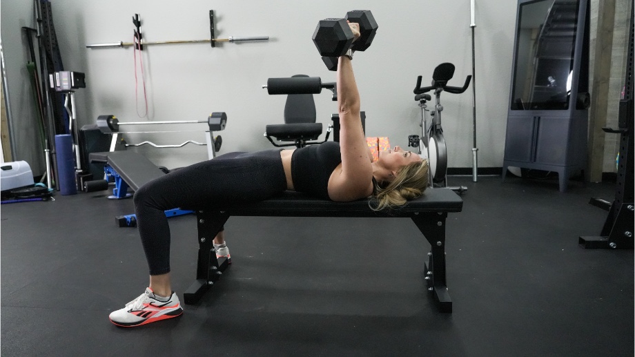 Side view of our tester doing bench presses on the Bells of Steel Flat Utility Bench.