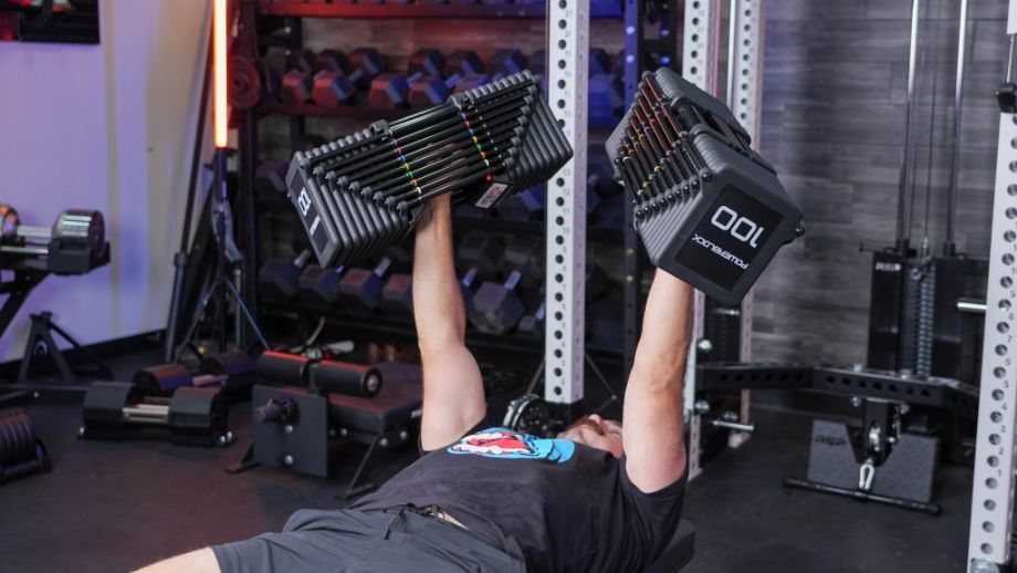 Man benching with the PowerBlock Pro 100 EXP Dumbbells