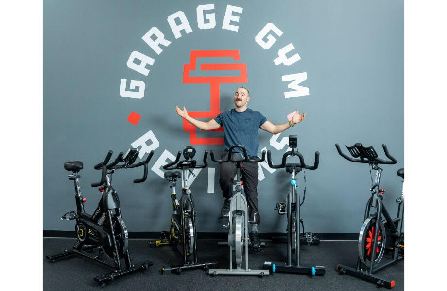 best bikes under 500 feature photo coop on bike arms raised surrounded by bikes in front of garage gym reviews wall
