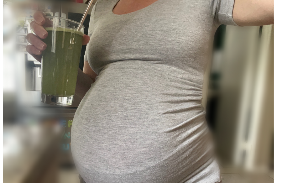 An image of a pregnant woman drinking greens for best greens powder for pregnancy