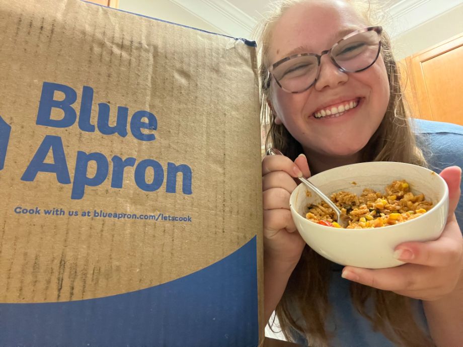 Woman eating a meal from Blue Apron