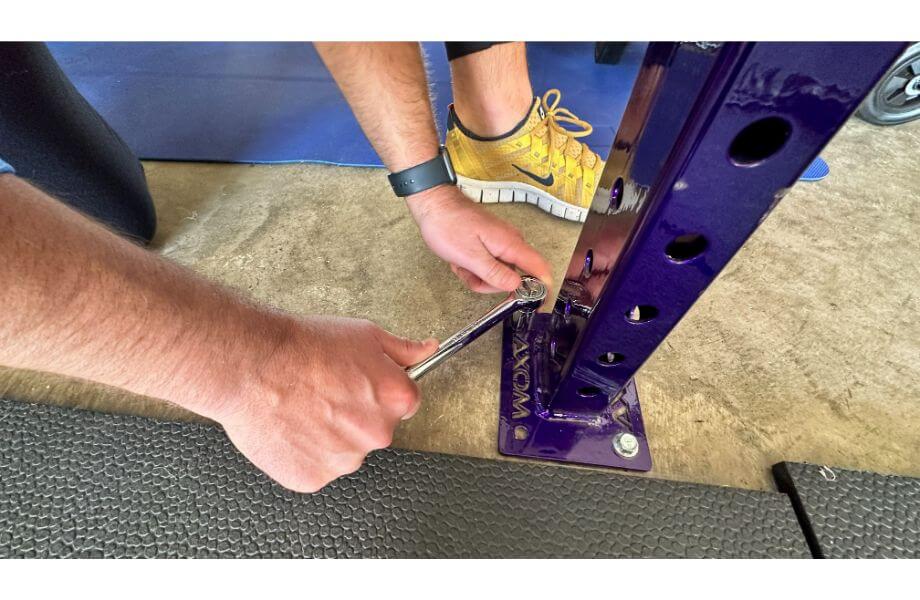 bolt squat rack to floor tool in use