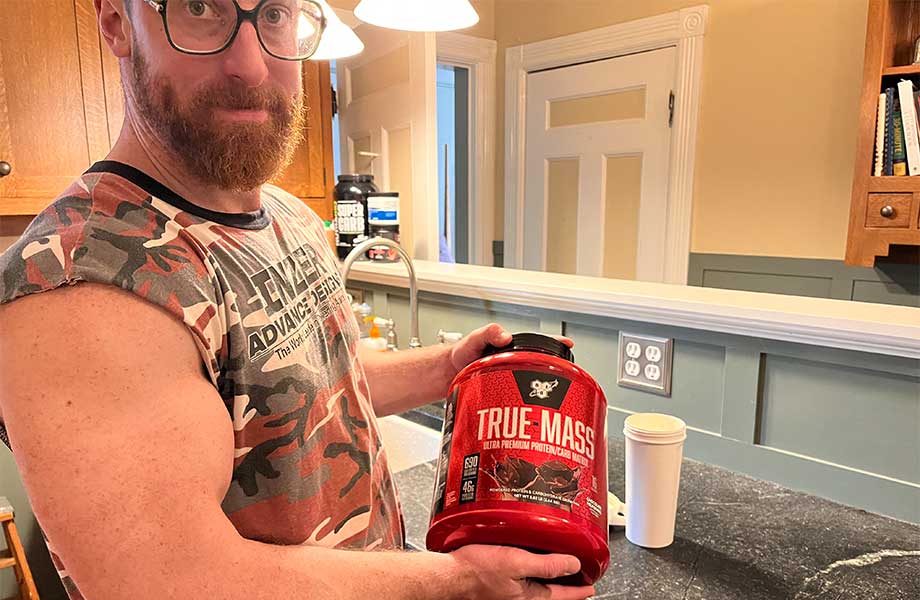 Man holding a tub of BSN True Mass