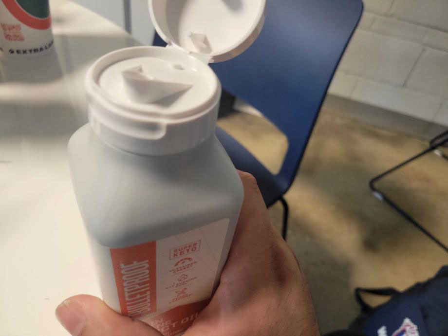 A person holds a container of Bulletproof MCT Oil