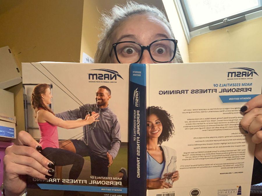 Woman reading the NASM CPT textbook