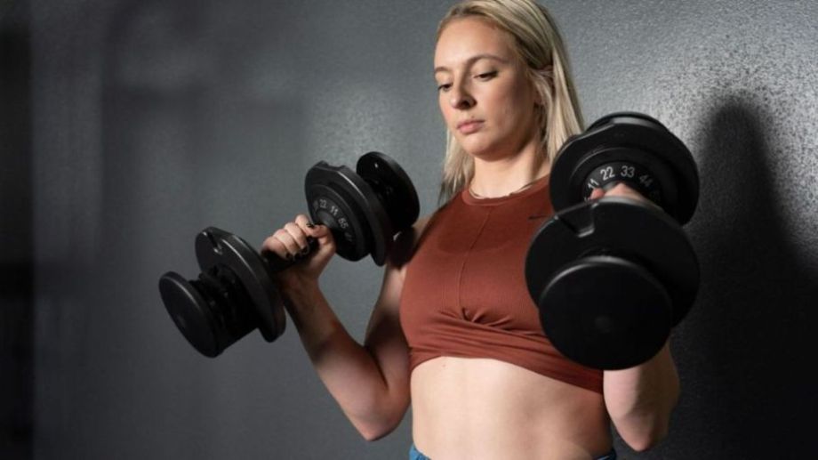 Woman using adjustable dumbbells