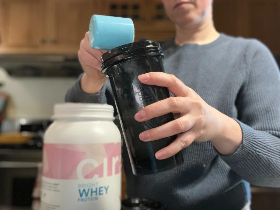 A woman is shown making a shake with Cira Bright Whey Protein