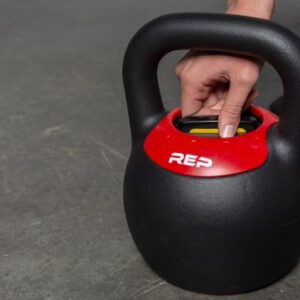 Up close photo of REP Fitness Adjustable Kettlebell featuring a hand on the adjustment mechanism.