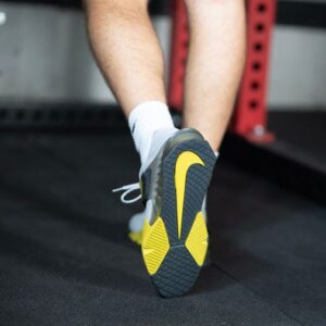 Closeup of the underside of Nike Savaleos weightlifting shoes showing the yellow Nike check mark.