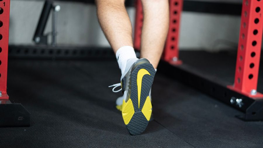 Closeup of the underside of Nike Savaleos weightlifting shoes showing the yellow Nike check mark.