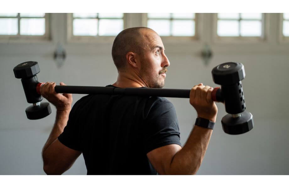 coop holding Jayflex hyperbell bar over shoulder