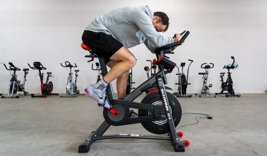 Coop riding the Schwinn IC4 Bike in a gym with a row of other exercise bikes in background