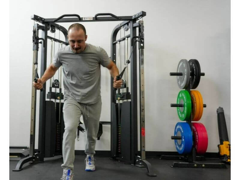 coop using titan fitness functional trainer with arms in cables lunging forward