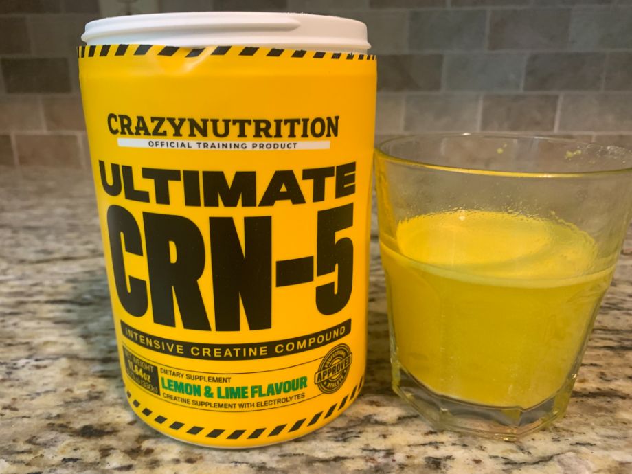 A yellow drink next to a yellow container of Crazy Nutrition CRN-5.