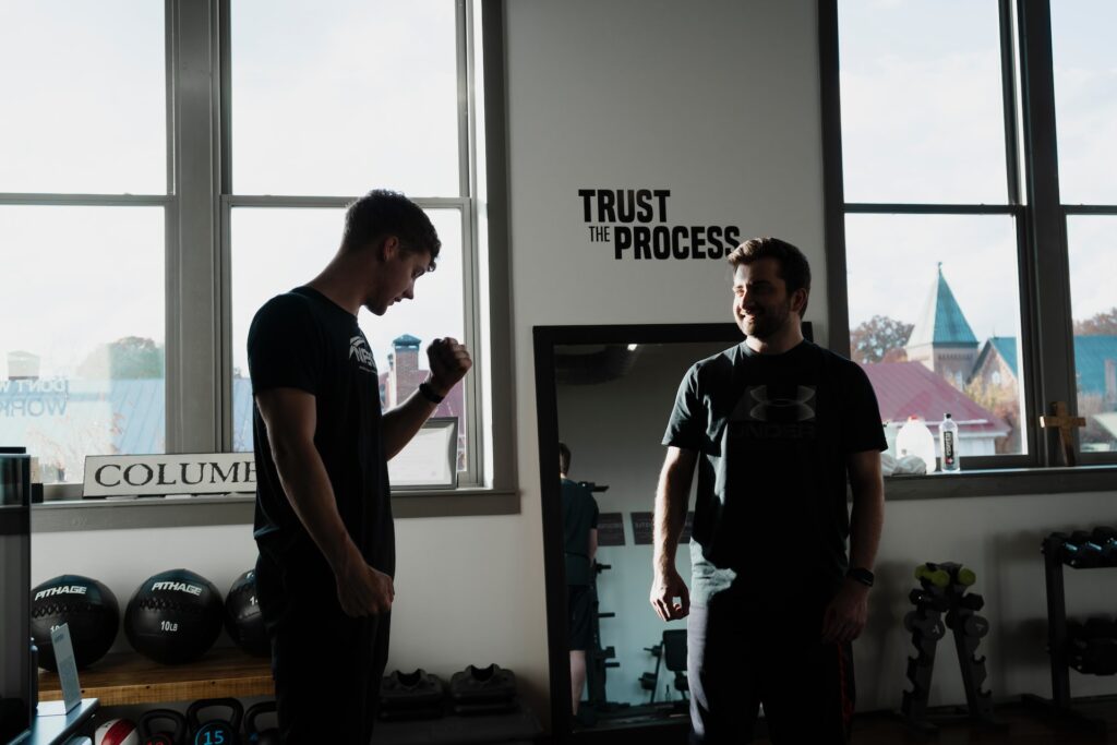A personal trainer coaching a man in a gym