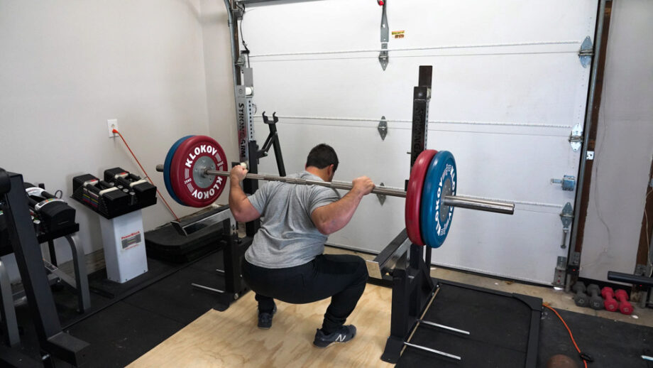 man squatting with the StrongArm Sport Combo Rack