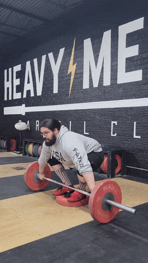 Man performing a snatch deadlift from a deficit