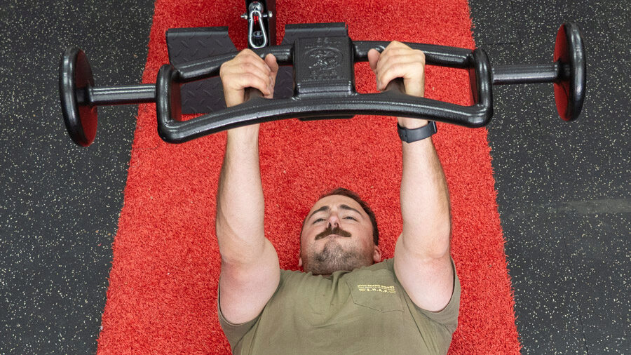 coop performing a bench press with the Mutt Bars Weighted Exercise Bar