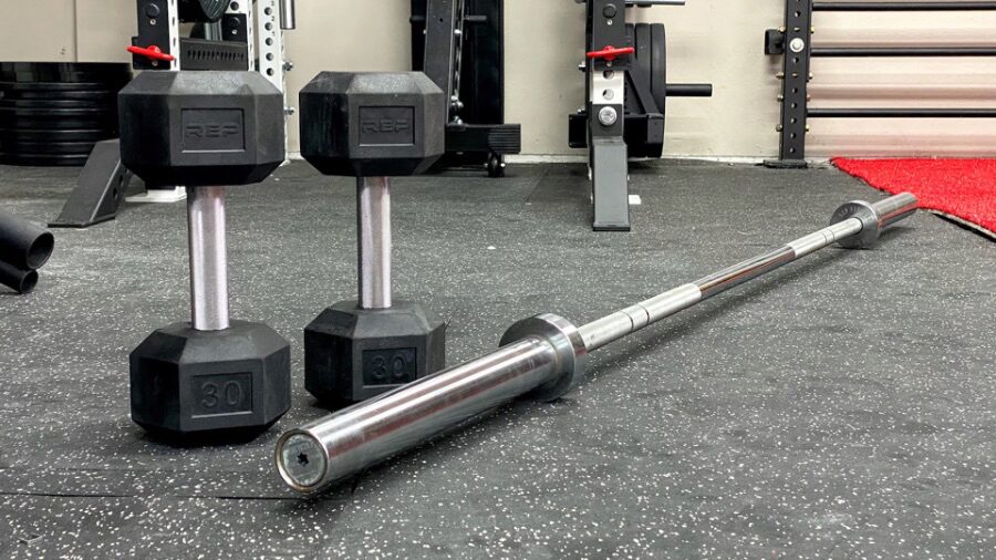 A pair of dumbbells and a barbell in a home gym