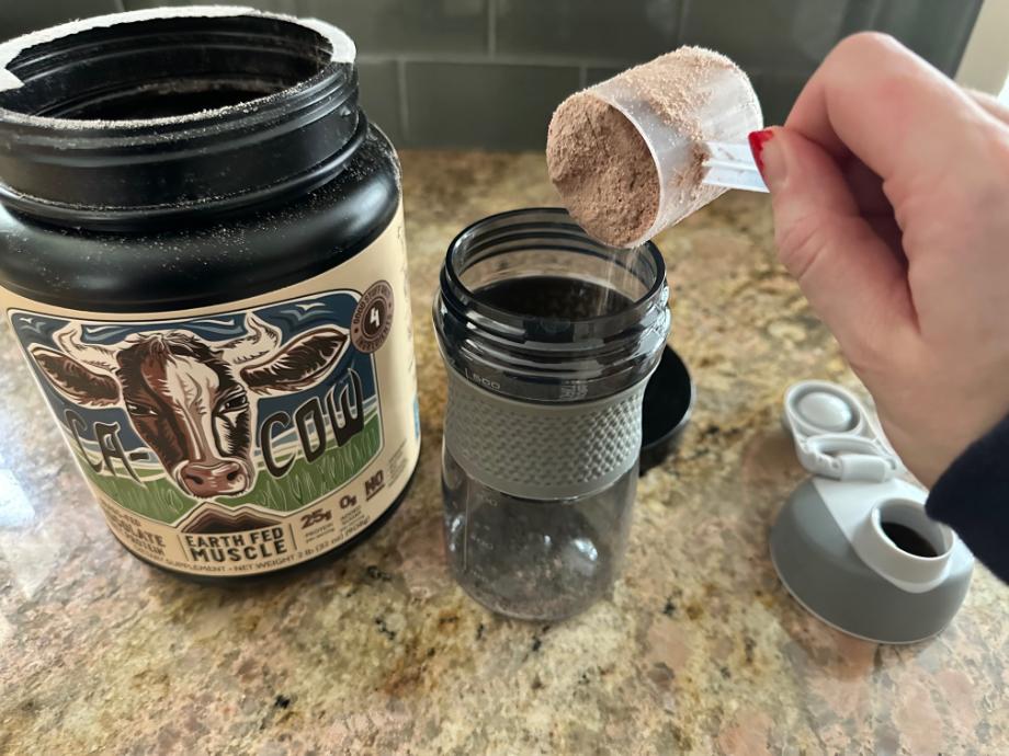 An image of Earth Fed Muscle protein powder going into a shaker