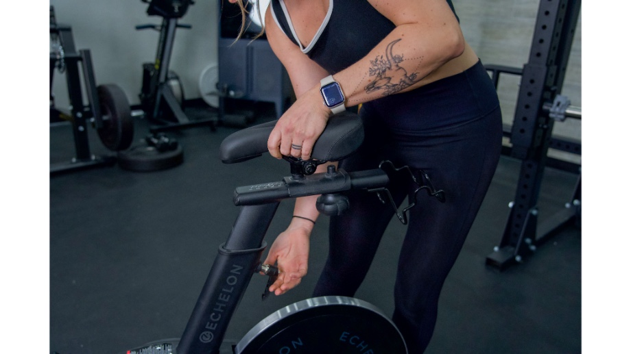 An image of a woman adjusting the seat on the Echelon EX-5