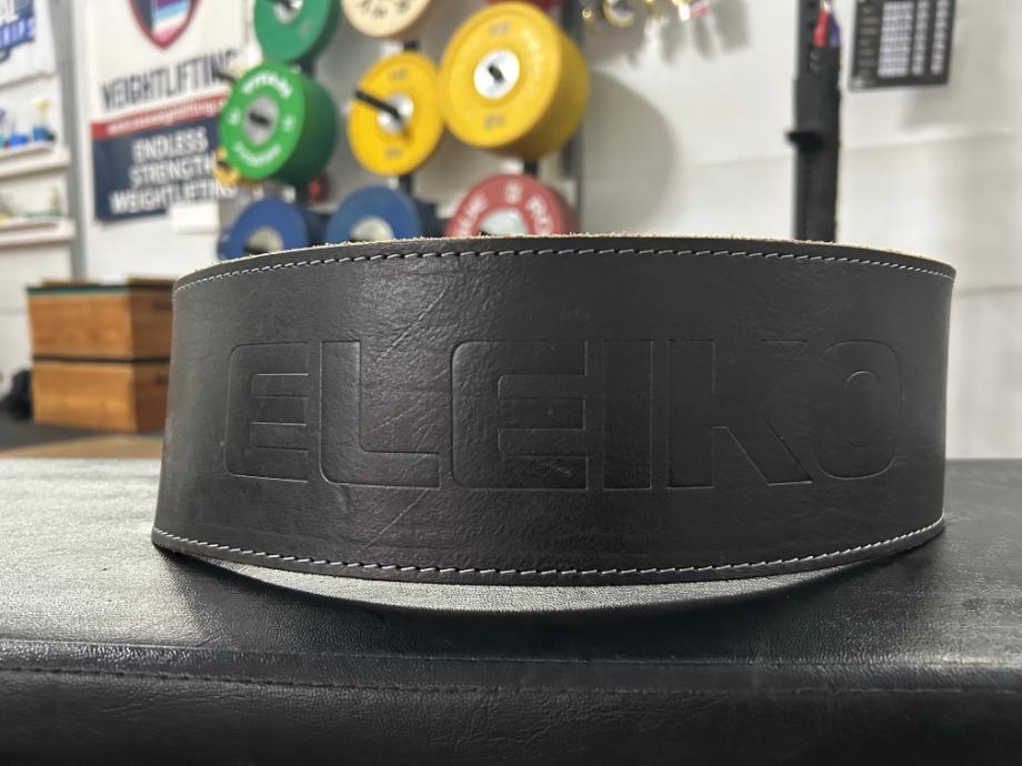 A close up view of the Eleiko Weightlifting Belt resting on a weightlifting bench. 