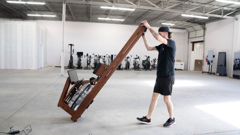 man moving a water rowing machine