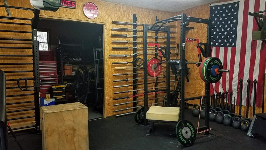 A safety squat bar in a squat rack in a garage gym