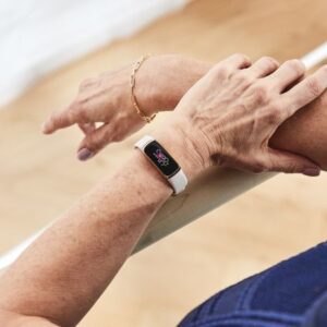 Fitbit Luxe in use on someone's arm.