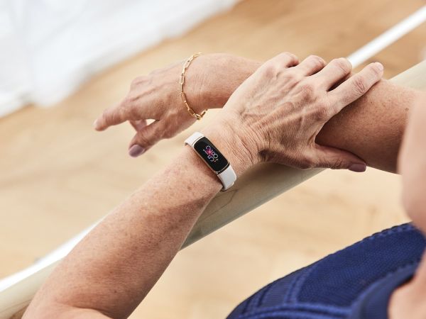 Fitbit Luxe in use on someone's arm.