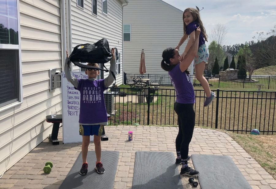 A mom doing a workout with her two kids