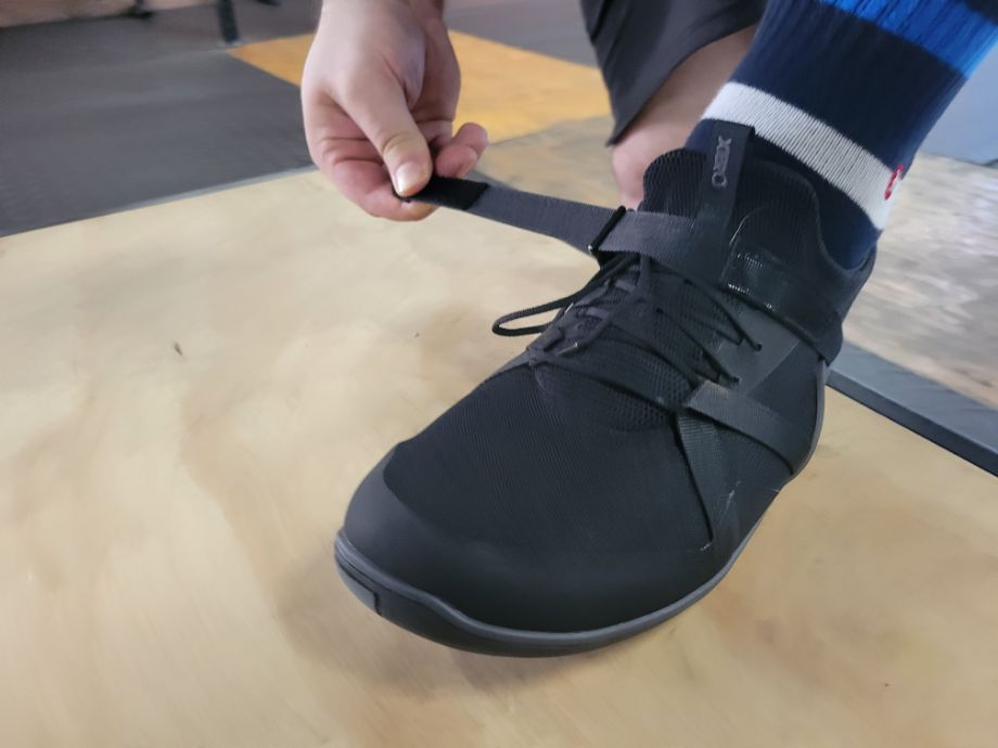 Man adjusting the velcro midfoot strap of the Forza Trainer