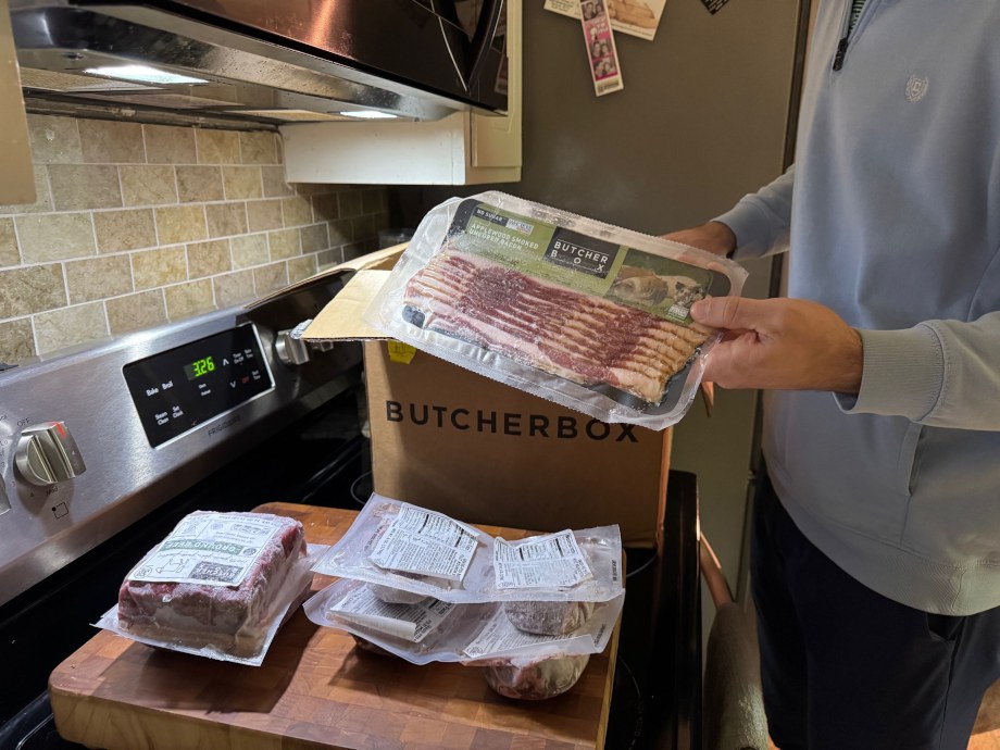 A person holds up free bacon from ButcherBox.