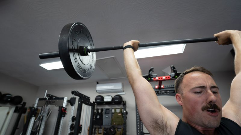 Coop lifting a barbell that has Fringe Sport Army Weight Plates