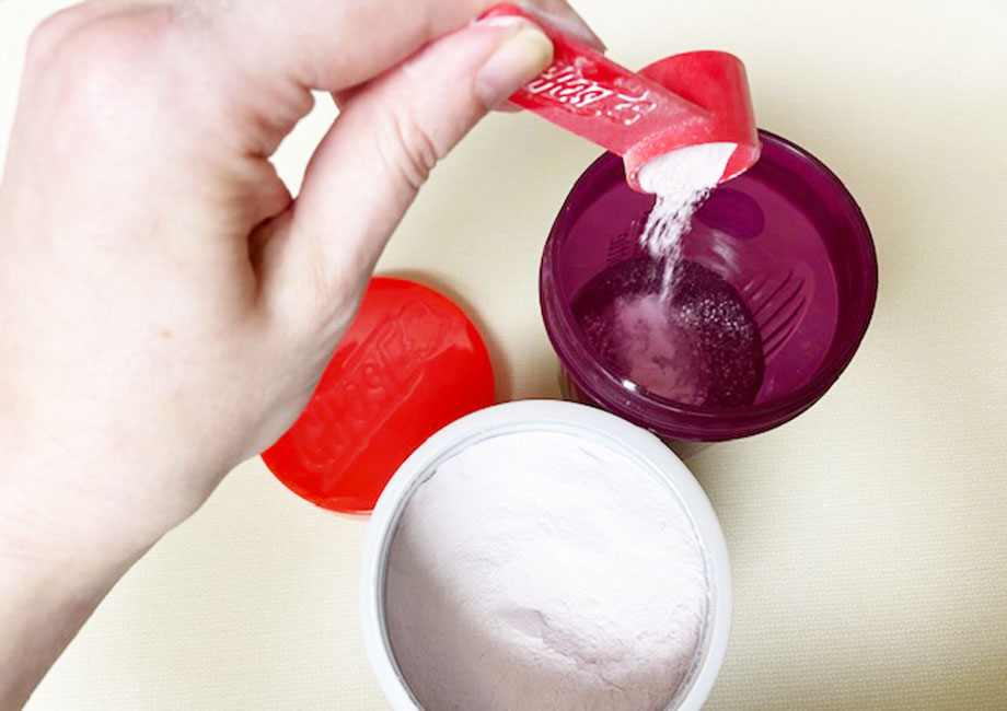 Looking down on a scoop of Ghost BCAAs being poured into a purple shaker cup