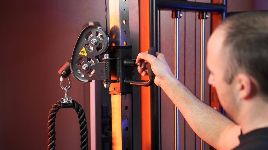 Coop uses the anodyzed handle to adjust the load height on a Gronk Fitness Functional Trainer.