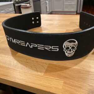 Black Gymreapers level belt, unbuckled and sitting on a table.