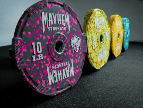 A series of Gymbro Mayhem Strength Neon-Fleck bumper plates are displayed in a row