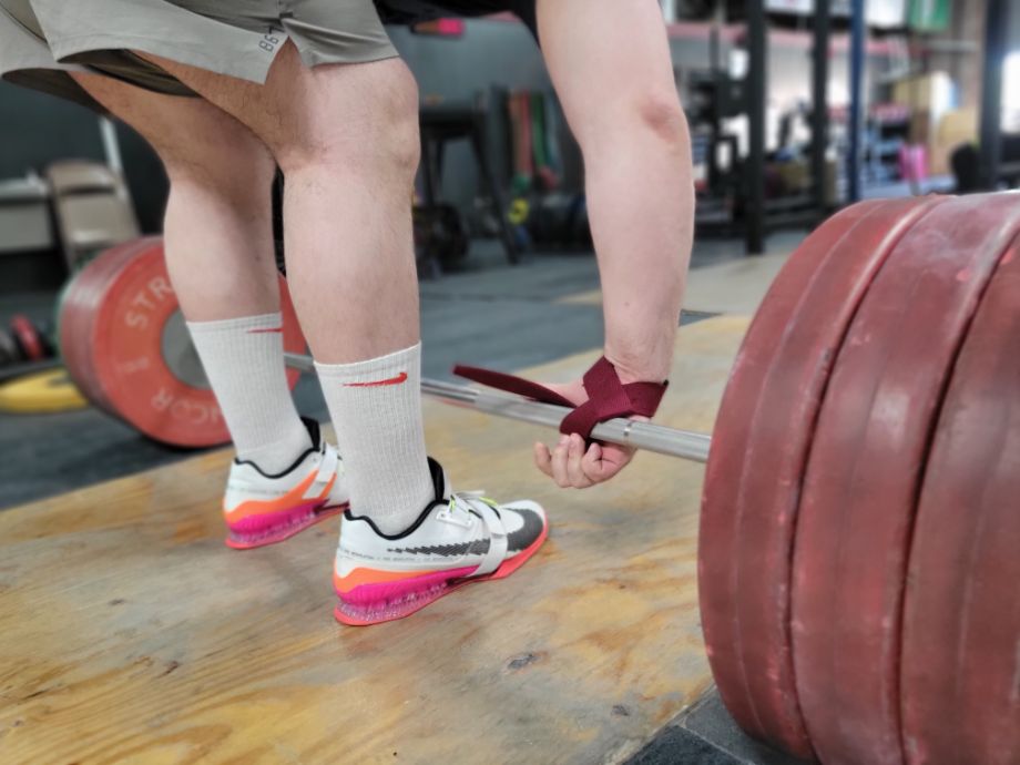 Man preparing to deadlift, wrapping the barbell with Harbinger Padded Cotton Lifting Straps