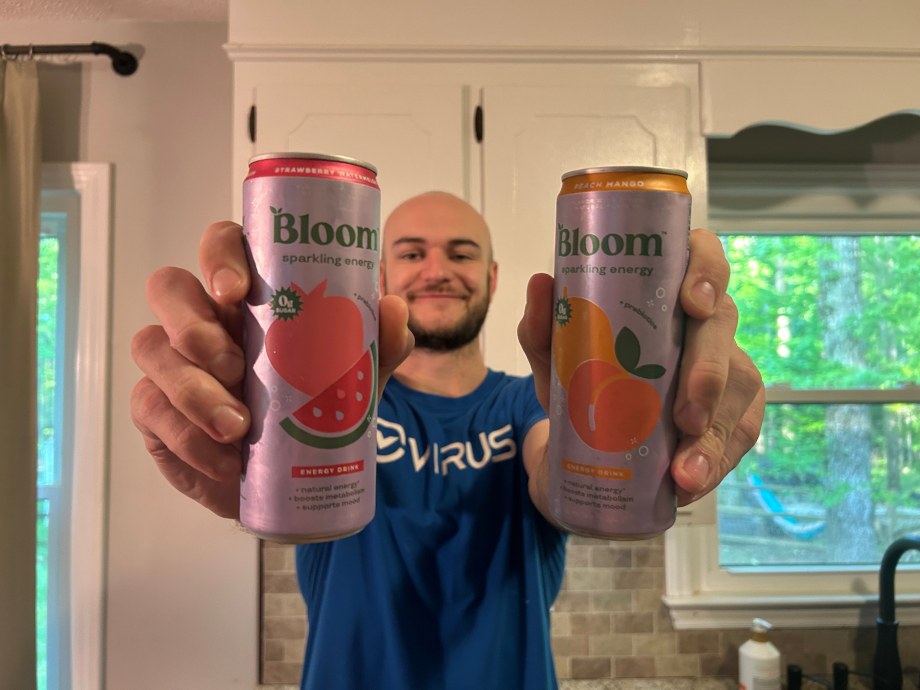 Our tester holds up cans of some of the best energy drinks.