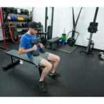 holding dumbells sitting hammer strength bench