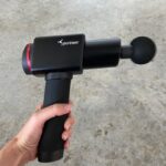 Holding the Sportneer Elite D9 massage gun