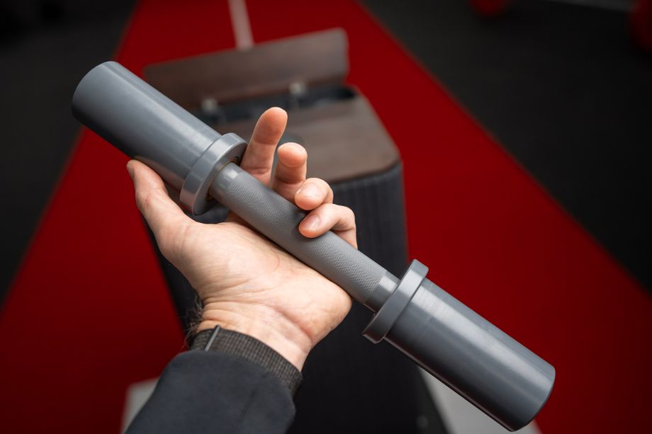Hand holding an empty loadable dumbbell handle