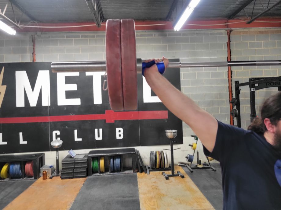 Man at the top of a snatch using the Ironmind Sew Easy Lifting Straps