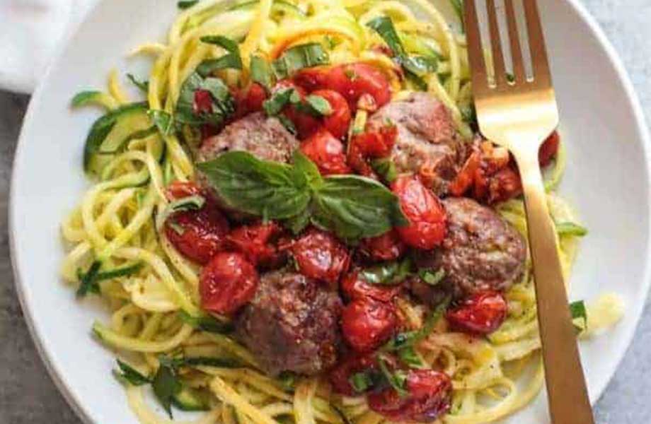 a plate of italian meatballs with zoodles